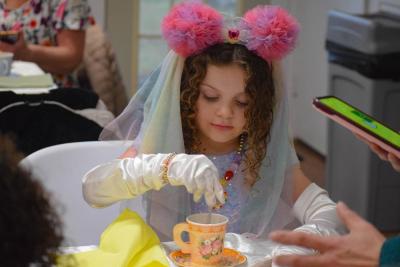Camila Sovik, age 6, stirs some sugar into her tea. Photos by Kat Sheridan