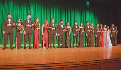 The entire cast pose in the formal wear at the end of the show.