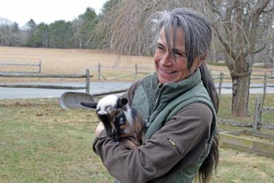 Shannon Lawrence warms up one of the goats.