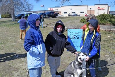 Some kids pet a dog at the protest.