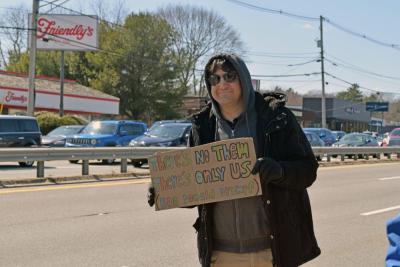 A man shows his sign calling for community.