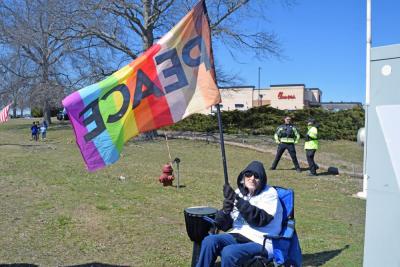 Jeanne Robinson, the organizer of the Dartmouth protest, waves a peace flag.