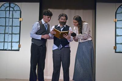 Dimirtry (Jack Nylin,) Vlad (Nolan Woodard,) and Anya (Emerson Palumbo) look at a book on the royal family. 