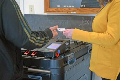 A voter grabs an "I voted" sticker. 