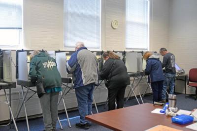 Voters at Town Hall fill in their ballots. 