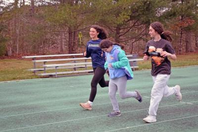 Delilah Dellecese runs alongside Hayden Barriteau and Etta Hall.