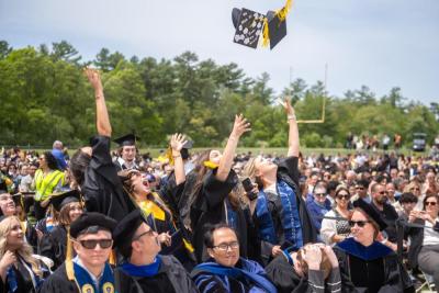 The students toss their caps in the air in celebration. Source: David James 