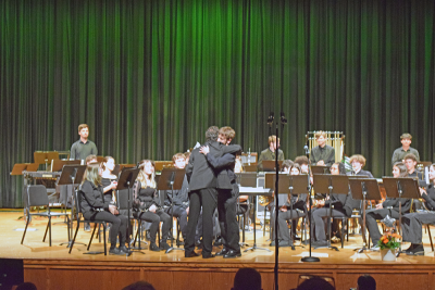 Noah Veloso hugs percussion director Alex Ollivierre. 