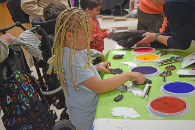 Miley, 2, makes stamp art at the Buttonwood Zoo table. 