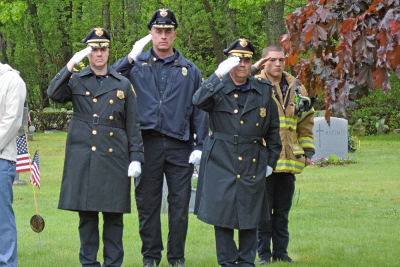 Members of the police and fire department salute during "Taps."