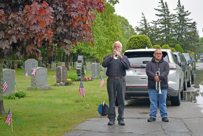 The crowd listens to a member of the Dartmouth Community Band perform "Taps."