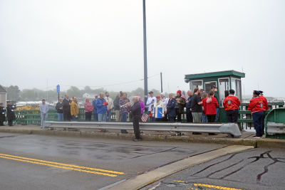 The crowd listens to a member of the Dartmouth Community Band perform "Taps."