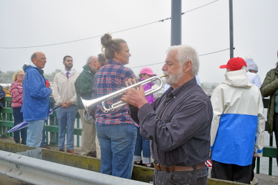 The crowd listens to a member of the Dartmouth Community Band perform "Taps."
