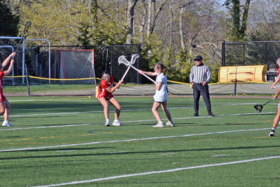 Kaylie Tyler crosses sticks with an opposing player. 