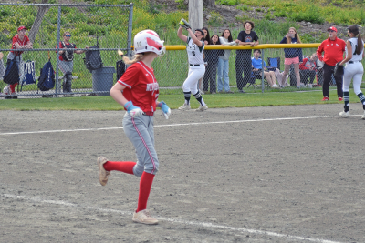 A player catches the ball in the background, making the New Bedford player out. 