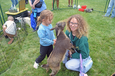 Ashley and Maliyah, age 3, pet a chewy goat. 