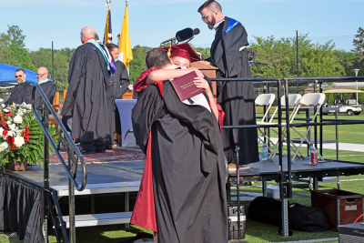 A student hugs a member of the Bishop Stang staff after she received herdiploma. 