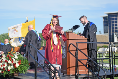 A student poses with her diploma. 