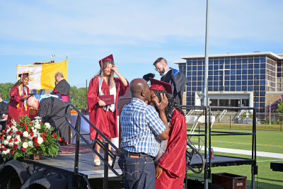 Stephanie Agbetorgoh's father kisses her forehead after she graduates. 