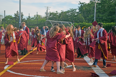 A group of students celebrate after graduating. 