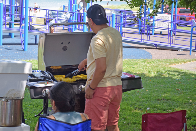 A man grills some squash. 
