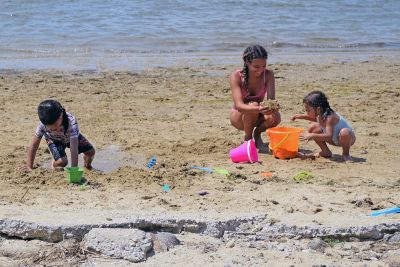 A group of girls plays in the sand. 