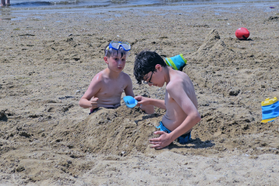Two boys play in the sand. 
