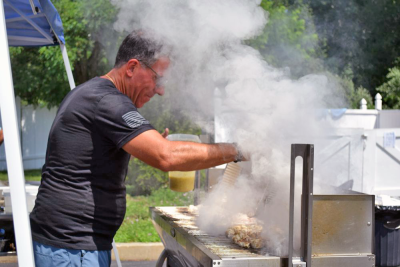 A man grills up some kebabs. 