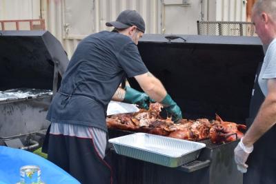 One of the cooks at Pig Pickin' tears apart the pig. 