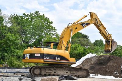 An excavator near a pile of contaminated soil at the former staging site on McCabe Street. Photo by Chris Shea