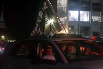 Fans with a Dartmouth flag out their sunroof. 