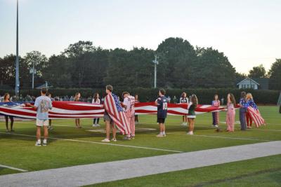 Dartmouth and Bishop Stang students hold a flag. 