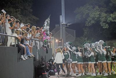 The cheerleaders and students celebrate together. 