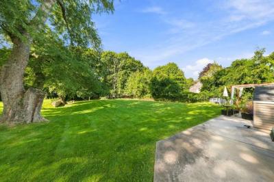 Large backyard lawn with mature trees behind 17 Beeden Road in Westport, MA