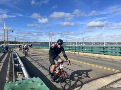 A cyclist gives a thumbs up as he passes over the bridge. 