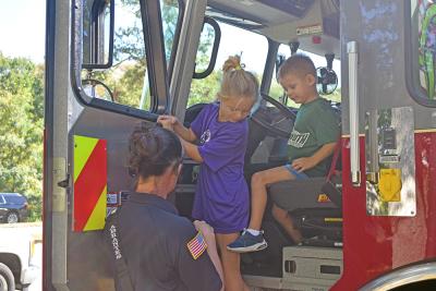 Declan and Claire learn more about the fire trucks. 