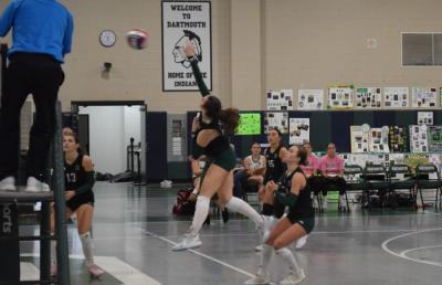 Madeline	Enos hits the ball over the net. 
