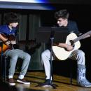 Jackson Hart performs “Revival” by Zach Bryan during Dartmouth’s Finest while pictures from his childhood and time at the school played in a slideshow behind him. Photo by Leighah Beausoleil