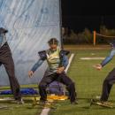 Marching band members dance as if they are in rough waters. s