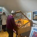Linda Mae Kristofik stocking some of her jewelry in a case. 