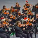 The orchestra students perform while dressed for Christmas.