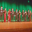 The entire cast pose in the formal wear at the end of the show.