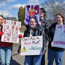 A group of four women show their signs. 