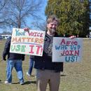 A man holds signs urging people to join.