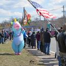 The rainbow unicorn for peace waves her peace flag.