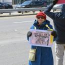 A woman shows her sign asking for joyful protest.