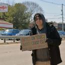 A man shows his sign calling for community.