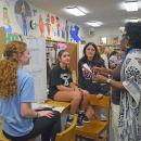 Sophie Sladewski, Arianna Sales, and Juliana Oliveira present their project on school nutrition to Youth Advocate Deloris Joseph. 