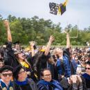 The students toss their caps in the air in celebration. Source: David James 