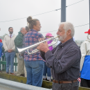 The crowd listens to a member of the Dartmouth Community Band perform "Taps."